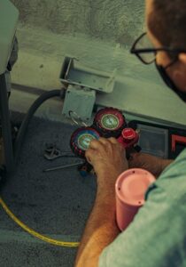 A technician is checking readings on a meter during repair