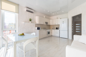 Interior of a spacious, light-filled kitchen with an air conditioning system.