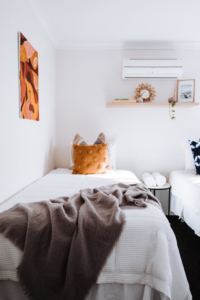 A light and airy bedroom with an air conditioner on.