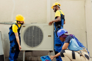 HVAC technicians replacing an old air conditioner unit, demonstrating a typical air conditioning system upgrade.