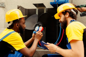 HVAC system repair technician refilling Freon into an external air conditioner unit using a manifold measurement device to ensure proper pressure and cooling performance.