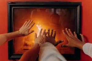 People Warming Hands In Front Of Heating System