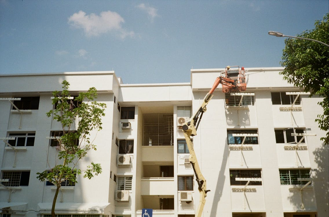 Hoist near an apartment building for AC repair and installation.