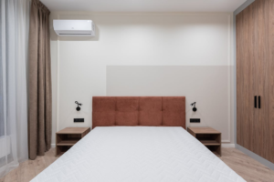  Interior of a bedroom with a large bed, wardrobe, and air conditioning system.