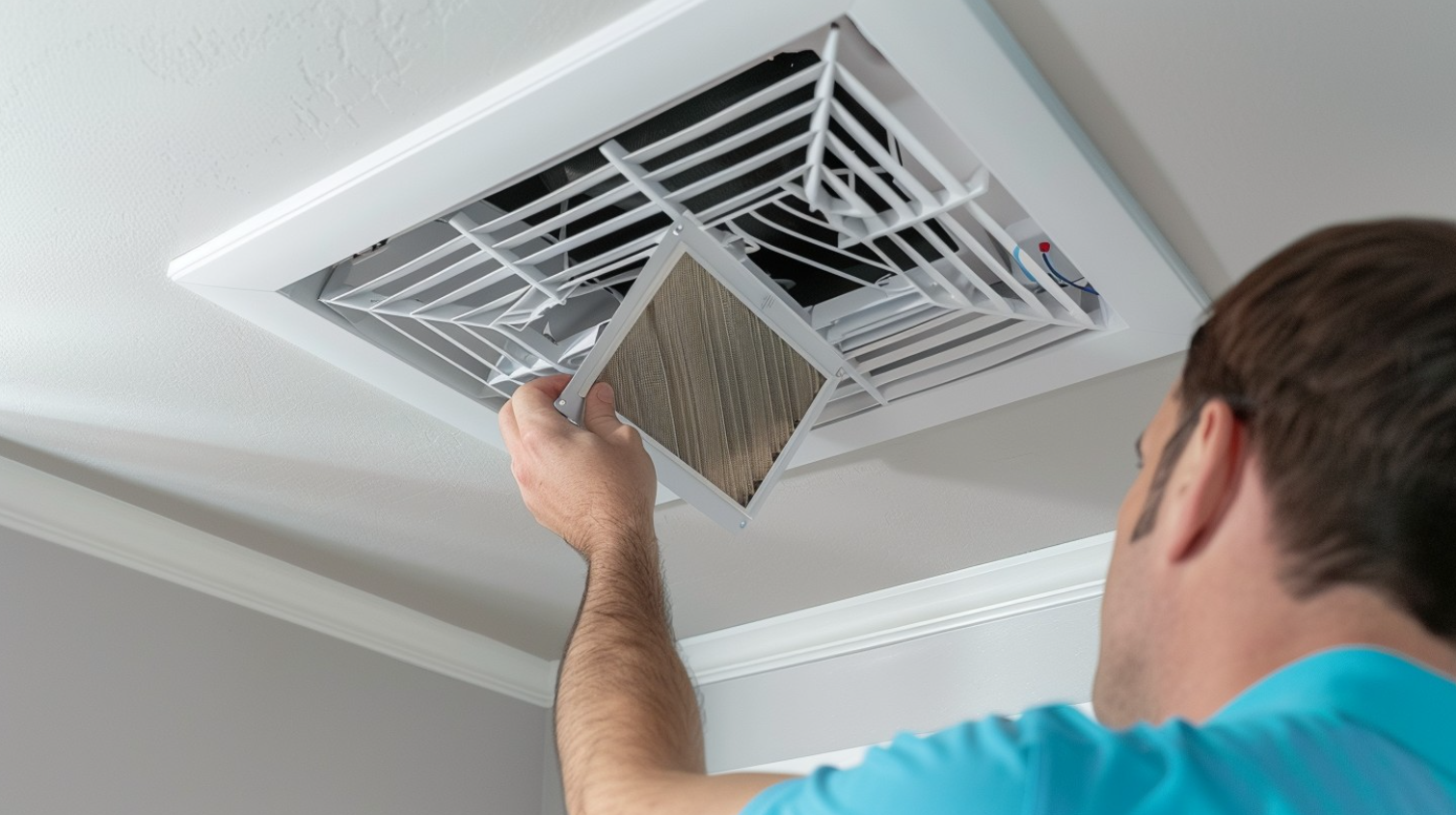 Technician replacing an air filter in an HVAC system.