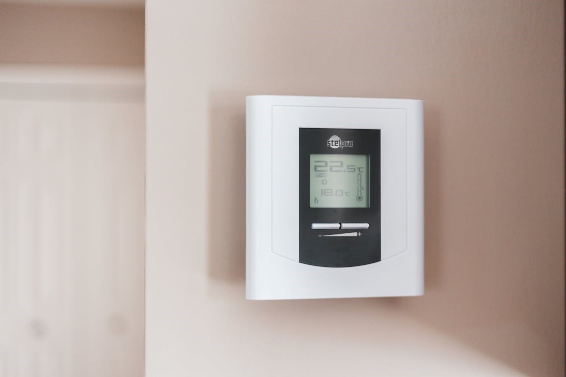 A white thermostat is mounted on the wall.