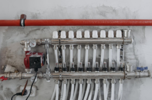 A technician inspecting and adjusting a white radiator near a window