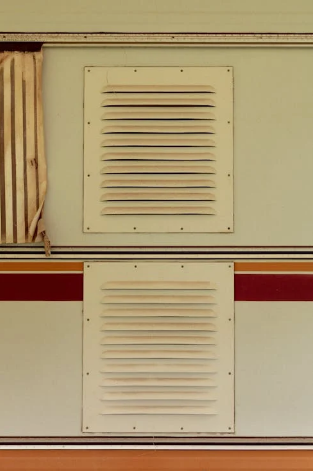 Two beige ventilation grilles on a light-colored wall.