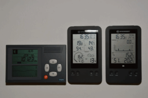 Three digital advanced thermostats, displayed on a light surface.