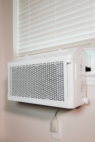 A white window air conditioning unit installed in a window